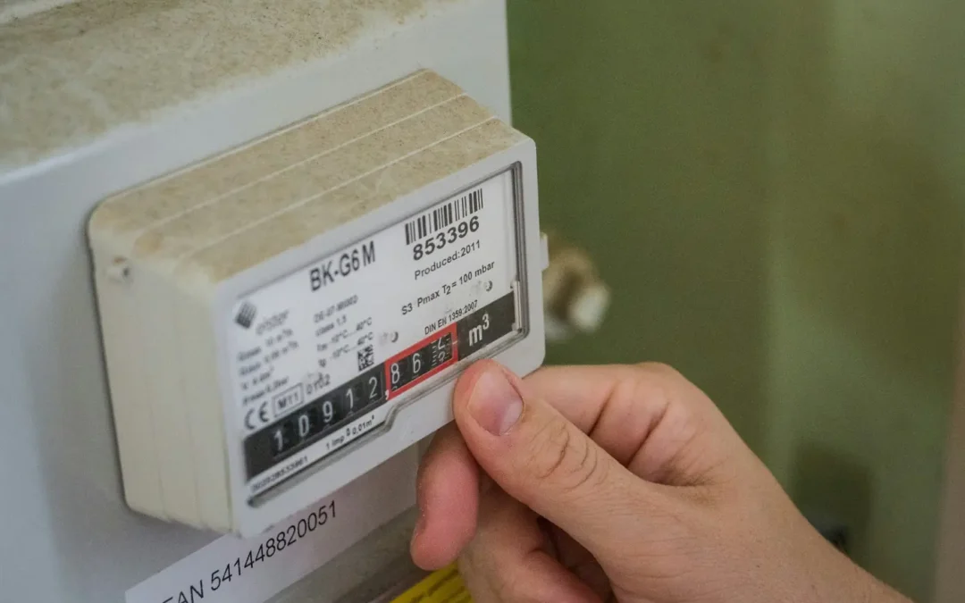 Hand an einem Gaszähler bei einer Zählerstandskontrolle